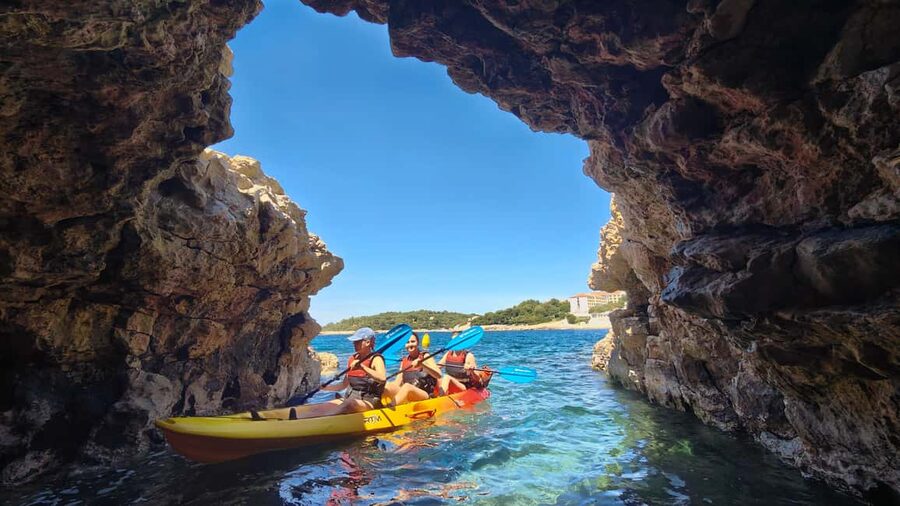 Pula: Cave Kayak Tour, Snorkeling and Island Jumping - Entering the pigeon cave by kayak