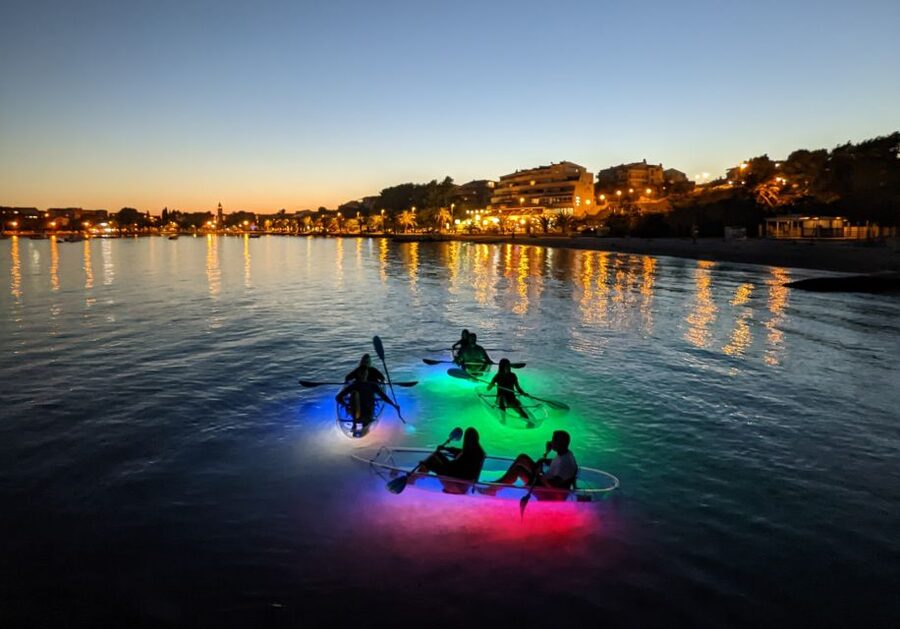 Split: Illuminated Evening Guided Kayaking Tour - Back on the sea, with rocks and coastal homes